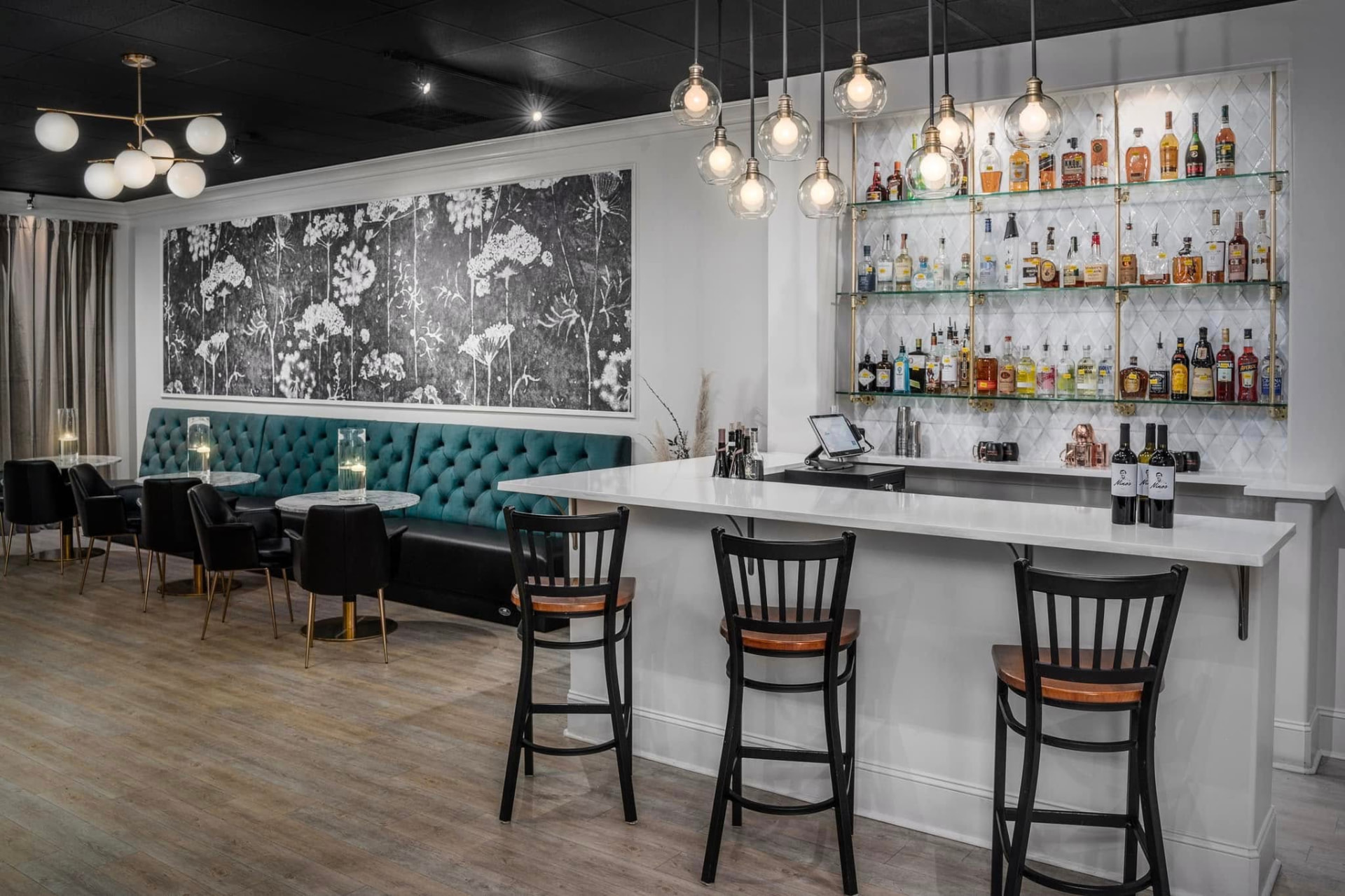The lounge with a teal banquette and floral mural