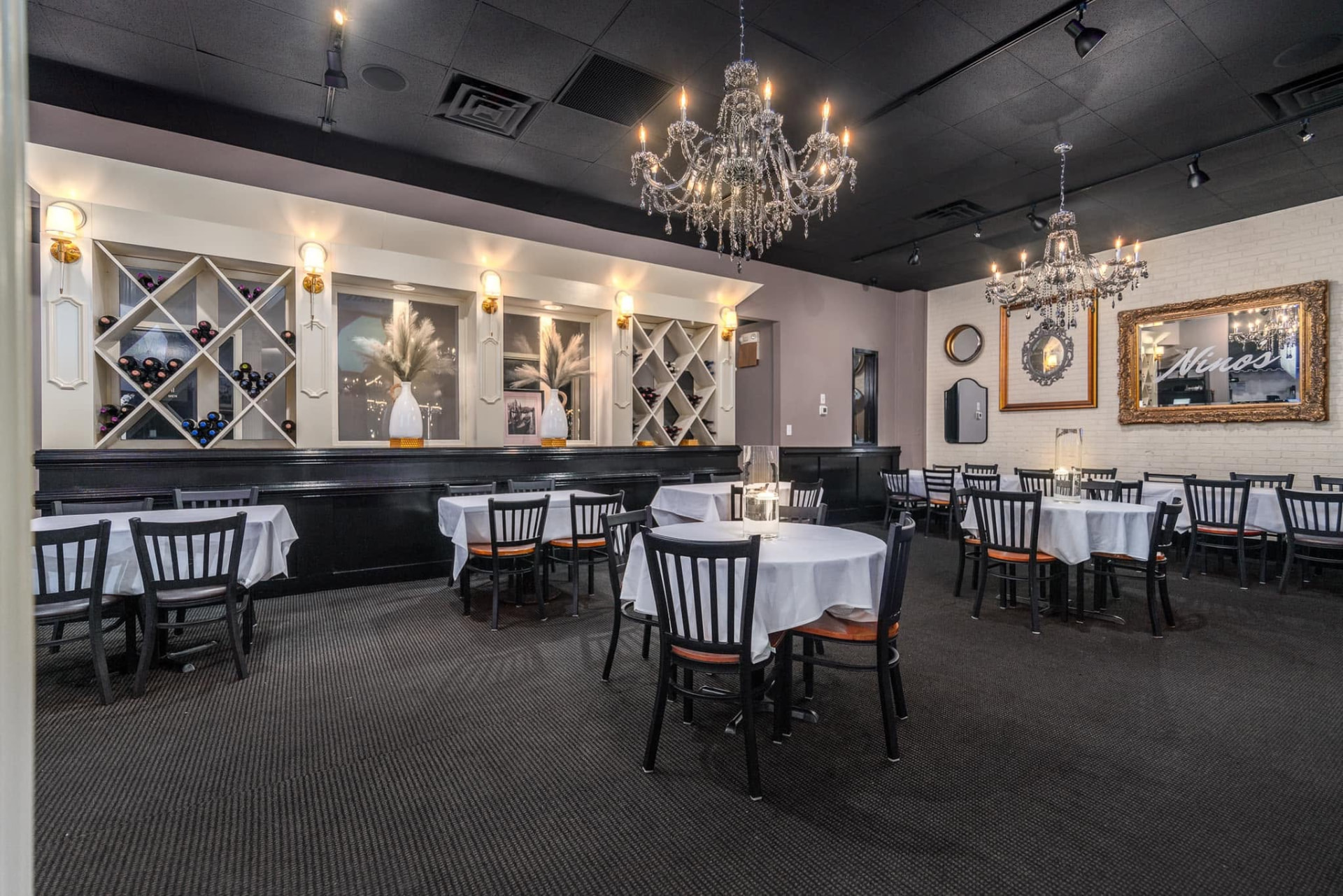 The dining room with chandeliers and white tablecloths