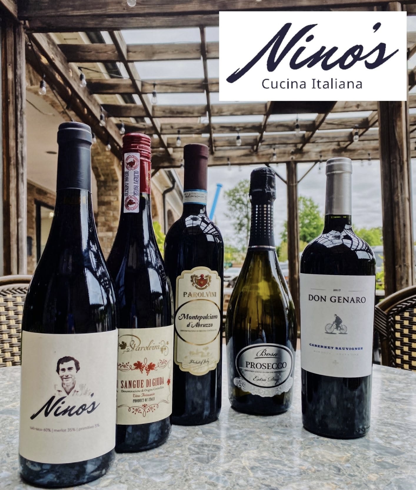 Nino's wine bottle lineup on a marble table